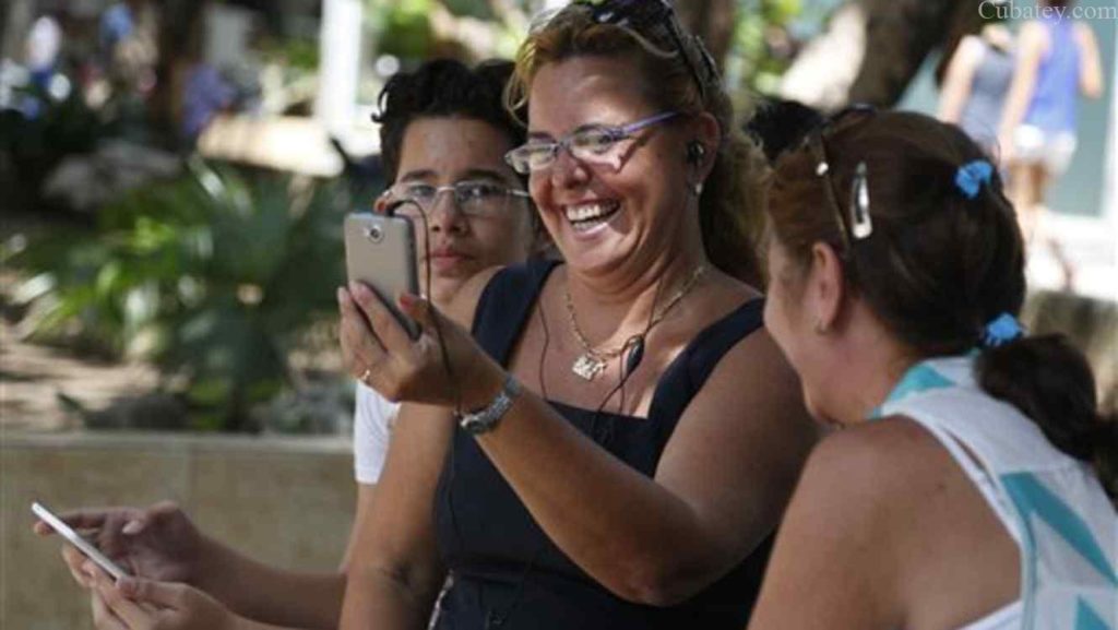 Acompañada por su sobrino y una aimga, Laura Martínez se comunica con su hijo en Canadá utilizando uno de los nuevos puestos de wi-fi públicos en La Habana, Cuba, el jueves 2 de julio de 2015. 